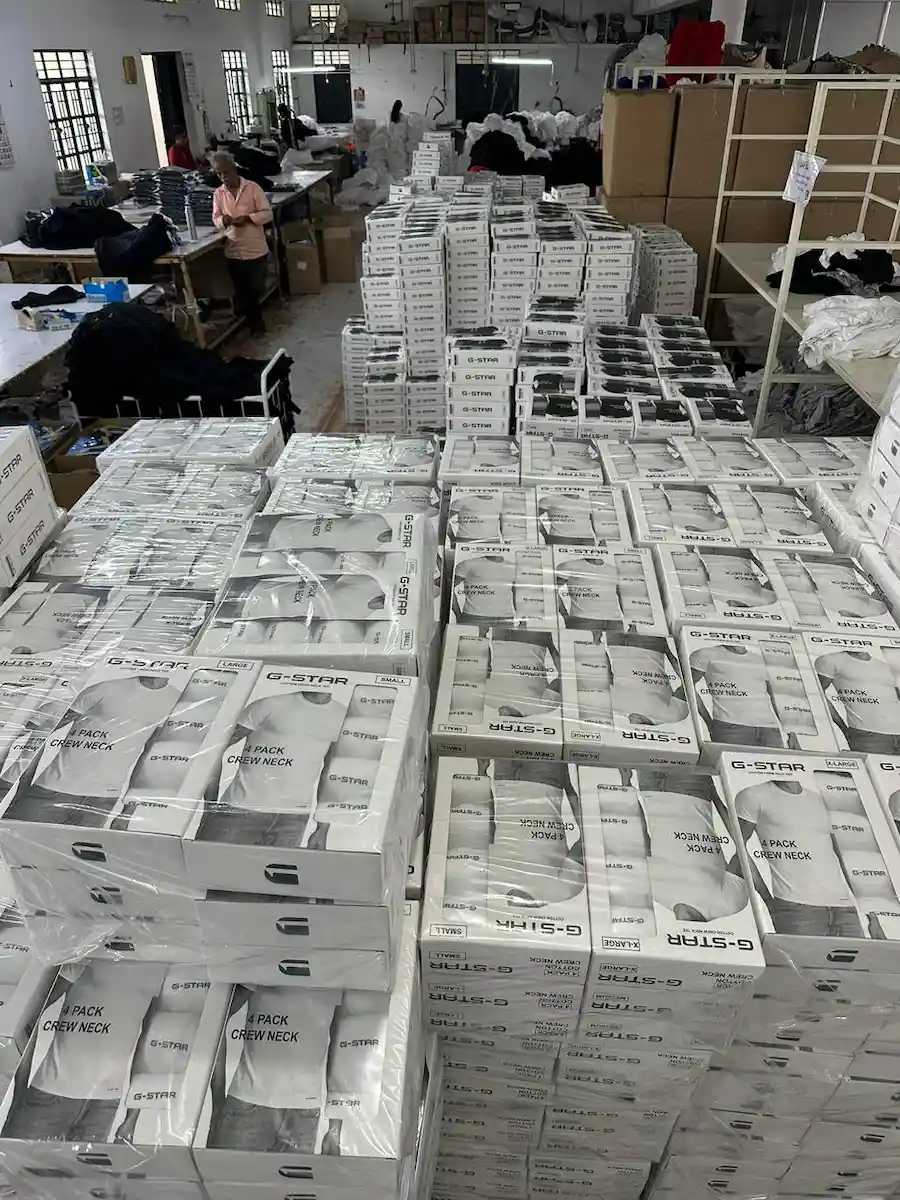 Pallets and stacks of custom branded apparel gift boxes ready for corporate distribution