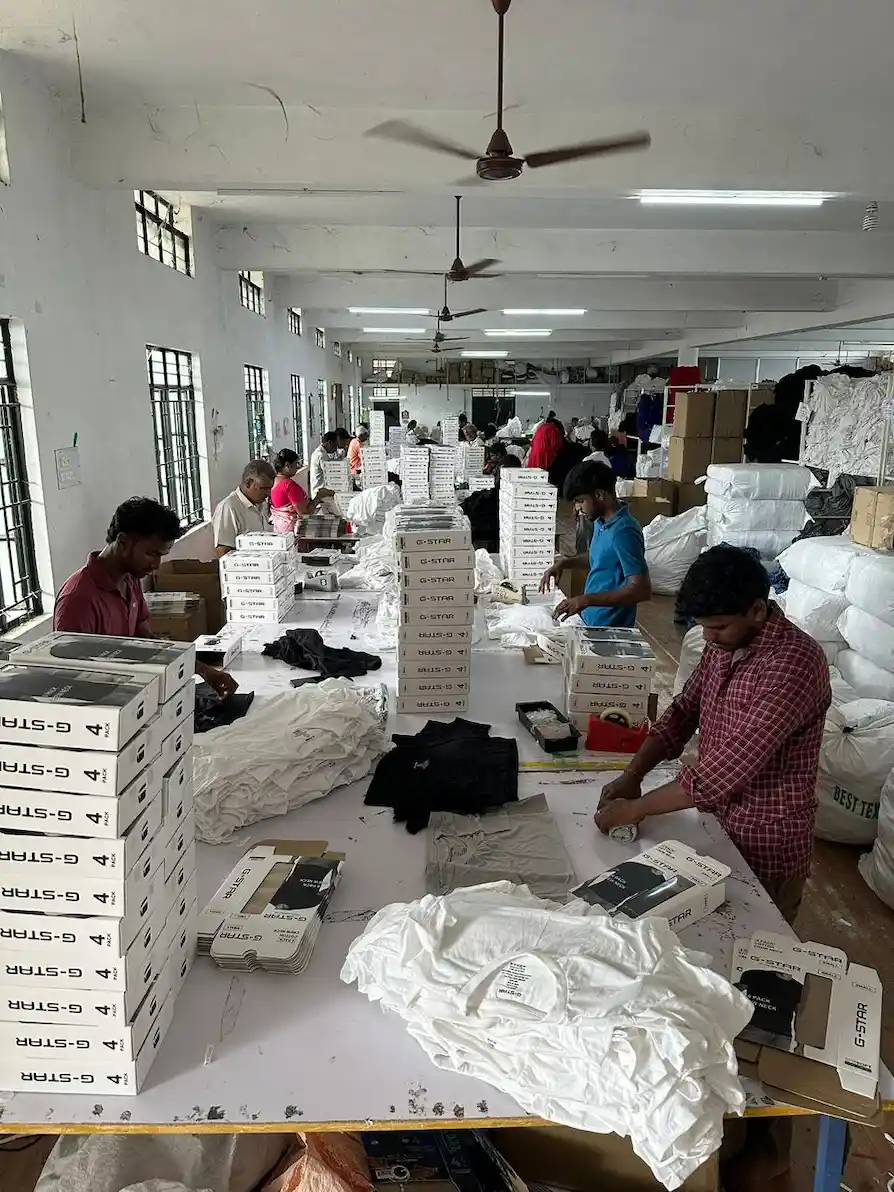 Packaging line assembling branded t-shirt boxes for corporate employee onboarding kits