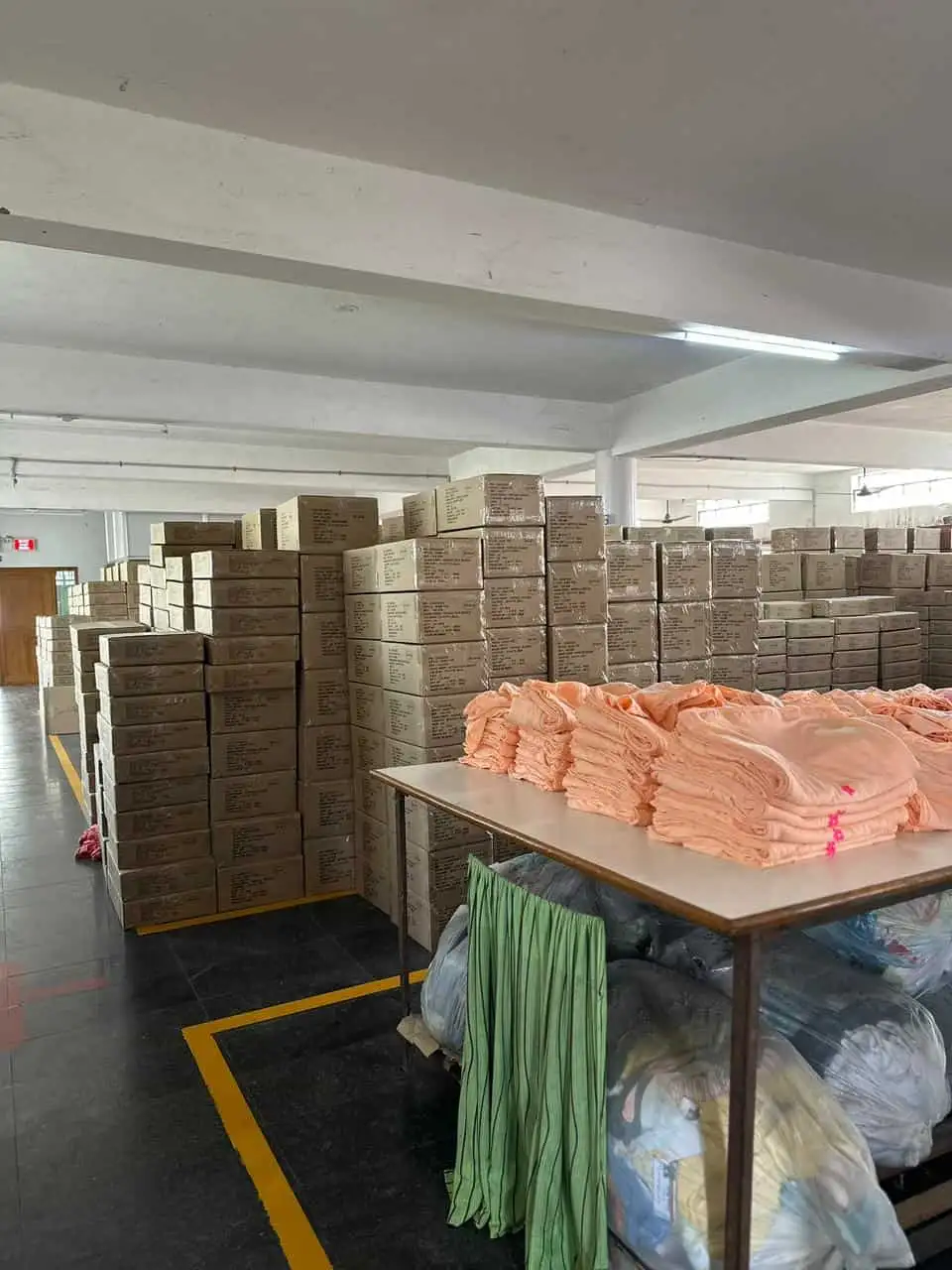 Folded apparel batches and stacks of packed corporate boxes ready for courier dispatch