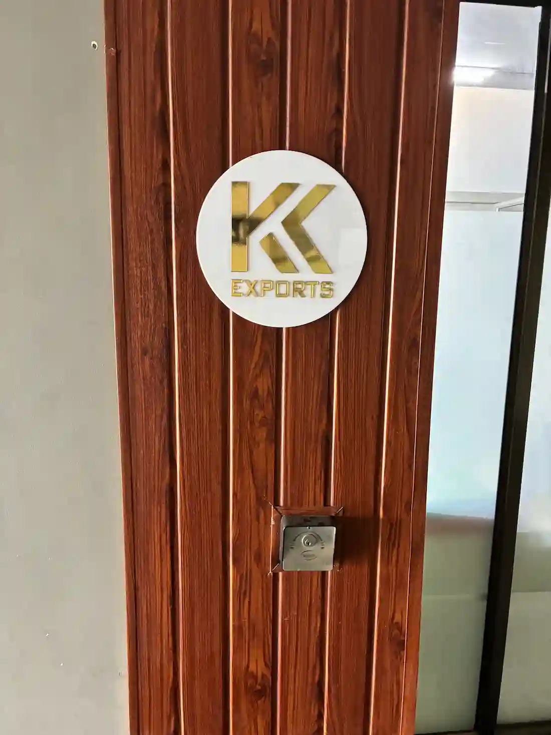Golden K.K. Exports logo signboard mounted on wooden finish office door