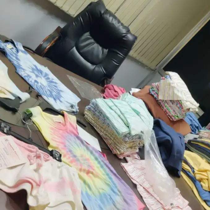 Tie-dye and casual apparel samples displayed on boardroom table for client selection